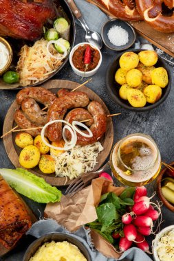 Karanlık arka planda Alman mutfağı. Izgara et ve abur cubur. Üst görünüm.