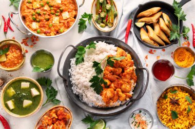 Hafif arka planda Hint yemeği çeşitleri. Geleneksel gıda konsepti. Bulaşıklar ve aperatifler. Üst görünüm.