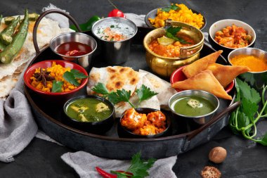 Siyah arka planda Hint Thali yemeği. Geleneksel gıda konsepti. Bulaşıklar ve aperatifler. Üst görünüm.