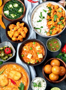 Hint mutfağı tabakları. Köri, tereyağlı tavuk, pilav, mercimek, paneer, samosa, baharatlar. Hint yemekli kase ve tabaklar. Üst görünüm.