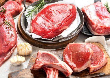 Çeşitli taze et türleri: gri arka planda domuz eti, sığır eti ve tavuk.