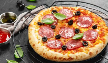 Koyu arkaplanda taze pişmiş pepperoni pizza. Lezzetli ev yapımı yemek konsepti. Üst görünüm.