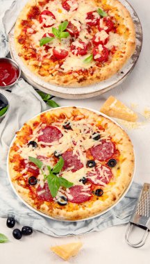 Beyaz arka planda taze pişmiş italyan pizzaları. Lezzetli ev yapımı yemek konsepti. Üst görünüm.