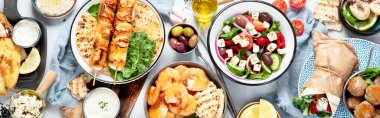 Yunan yemek geçmişi. Meze, jiroskop, souvlaki, balık, pide, Yunan salatası, tzatziki, çeşit çeşit peynir, zeytin ve köfte mavi arka planda. Geleneksel Yunan yemekleri seti. Üst Manzara. Panorama, bayrak.