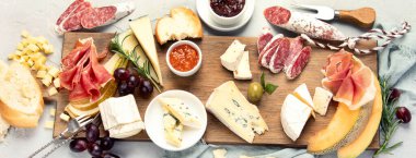 Hafif arka planda peynir çeşitleri. Gurme aperatifleri tepside. İtalyan yemeği konsepti. Üst Manzara. Panorama.