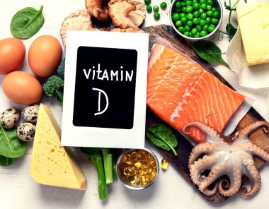 Beyaz arka planda D vitamini bakımından zengin ürünler, üst görünüm.