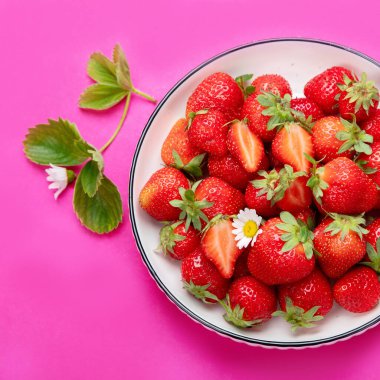 Pembe arka planda çilekler. Organik gıda kavramı. Üst görünüm,.