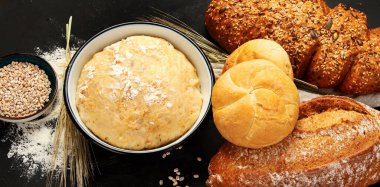Koyu arkaplanda taze ekmek çeşitleri. Taze ev yapımı hamur işi. Üst Manzara. Panorama.