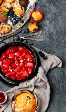 Pasta ve atıştırmalıklarla dolu bir tatlı masası. Gri arka planda çikolata. Üst görünüm, alanı kopyala.