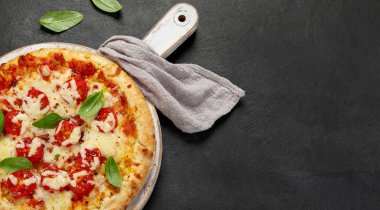 Koyu arka planda taze pişmiş pizza. Lezzetli ev yapımı yemek konsepti. Üst Manzara. Kopyalama alanı olan Panorama.