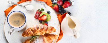 Taze kruvasanlarla, meyvelerle ve kahveyle kahvaltı. Güne Mükemmel Başlama. Üst Manzara. Kahvaltı konsepti. Kopyalama alanı olan Panorama.