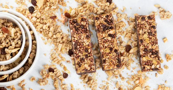 Granola bar. Sağlıklı tatlı tatlı snack. Mısır gevreği granola bar ile fındık, meyve ve çilek beyaz zemin üzerinde. Üstten Görünüm