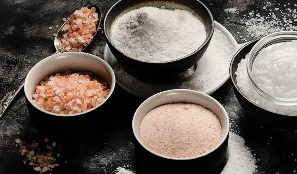 Farklı tuz türleri - beyaz, gül, siyah arka planda siyah. Üst görünüm.
