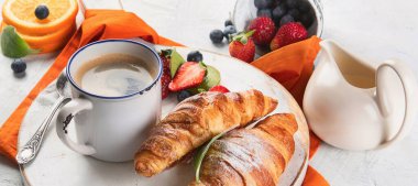 Taze kruvasanlarla, meyvelerle ve kahveyle kahvaltı. Güne Mükemmel Başlama. Üst görünüm.