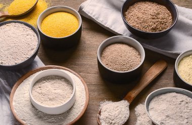 Tahta bir masadaki kaselerde farklı şekillerde un pişirmek. Üst görünüm.