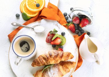 Taze kruvasanlarla, meyvelerle ve kahveyle kahvaltı. Güne Mükemmel Başlama. Üst Manzara. Kahvaltı konsepti. 