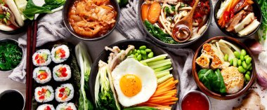 Geleneksel Kore yemekleri. Bibimbap, geleneksel Kore yemeği, pirinç, sebze, beyaz arka planda Kimchi. Üst Manzara. Panorama.