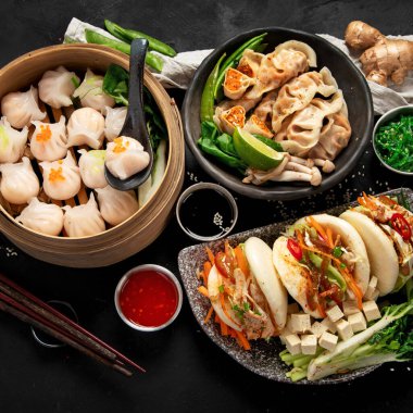 Çin mantısı, soya sosu, karanlık bir arka planda Çin mantısı. Geleneksel Asya yemekleri konsepti. Üst görünüm