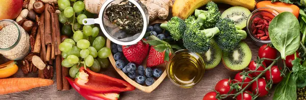 Tahta zemin üzerinde antioksidan ve vitamin açısından zengin doğal ürünler. Sağlıklı temizlik ve detoks yiyecekler - sebzeler, meyveler, fındıklar, süper yiyecekler. Panorama.