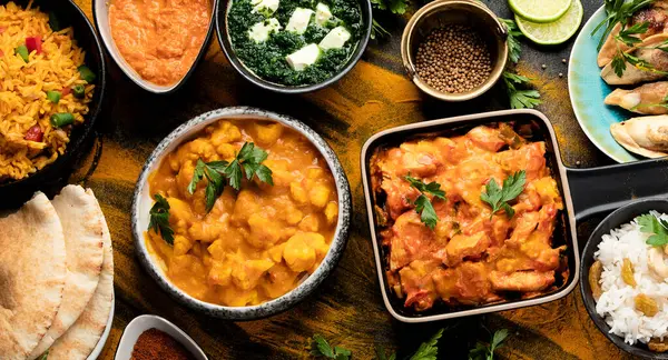 Siyah arka planda geleneksel Hint yemekleri. Hint mutfağı. Üst Manzara. Kopyalama alanı olan Panorama.