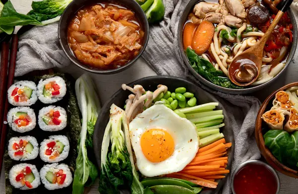 Geleneksel Kore yemekleri. Bibimbap, geleneksel Kore yemeği, pirinç, sebze, beyaz arka planda Kimchi. Üst görünüm.