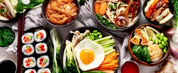 Geleneksel Kore yemekleri. Bibimbap, geleneksel Kore yemeği, pirinç, sebze, beyaz arka planda Kimchi. Üst Manzara. Panorama.