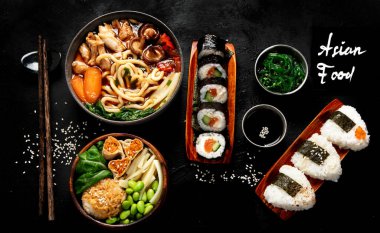 Çeşitli gurme Japon yemekleri. Suşi, rulo ekmek, siyah arka planda çorba ve pirinç. Üst görünüm.