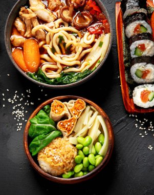 Çeşitli gurme Japon yemekleri. Suşi, rulo ekmek, siyah arka planda çorba ve pirinç. Üst Manzara. Boşluğu kopyala.