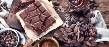 Kakao fasulyesi, pudra, kakao yağı, çikolata ve çikolata sosu ahşap arka planda. Üst Manzara. Panorama.