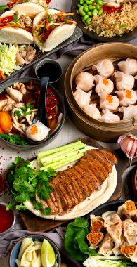 Koyu arkaplanda Çin yemekleri: tatlı ördek, çorba, buharda pişmiş çörekler, bambu buharlı buhar tenceresi, salata, pilav, sos. Asya tarzı ziyafet, üst görünüm. 