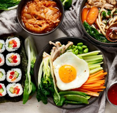 Geleneksel Kore yemekleri. Bibimbap, geleneksel Kore yemeği, pirinç, sebze, beyaz arka planda Kimchi. Üst Manzara. Boşluğu kopyala.