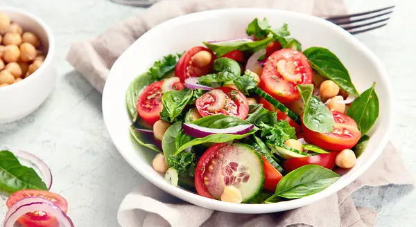Gri arka planda sağlıklı sebze salatası. Sebze aperatifi. Vejetaryen ve vejetaryen menüsü. Temiz ve detoks yeme konsepti. Üst Manzara. Panorama.