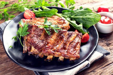 Kaba ahşap arka planda soslu ve otlu ızgara pirzola. Üst görünüm.