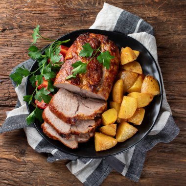 Ahşap arka planda patates ve sebzeli ızgara domuz eti. Üst görünüm.