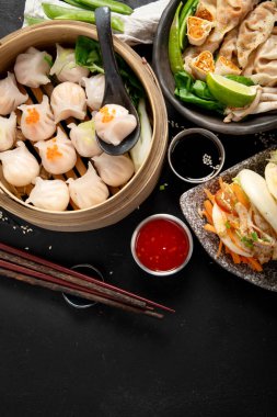 Çin mantısı, soya sosu, karanlık bir arka planda Çin mantısı. Geleneksel Asya yemekleri konsepti. Üst Manzara. Boşluğu kopyala.