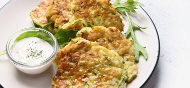 Kabaklı börek. Gri arka planda roka olan bir tabakta sebzeli vejetaryen kabaklı gözleme. Üst Manzara. Panorama.