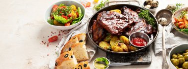 Beyaz arka planda fırında patates sebzeli ve zeytinli leziz pirzola. Üst Manzara. Kopyalama alanı olan Panorama.