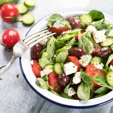 Mavi arka planda beyaz peynir tabağında taze sebze salatası. Geleneksel Yunan salatası. Üst görünüm.