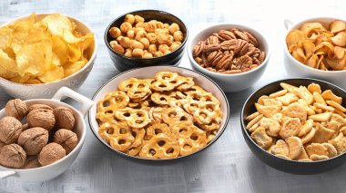 Farklı çerezler, cipsler, fındıklar, patlamış mısır ve kurabiyeler gri arka planda. Üst Manzara. Panorama.