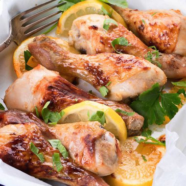 Ahşap bir arka planda fırında pişirilmiş tavuk budu. Üst görünüm.