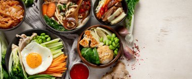 Geleneksel Kore yemekleri. Bibimbap, geleneksel Kore yemeği, pirinç, sebze, beyaz arka planda Kimchi. Üst Manzara. Kopyalama alanı olan Panorama.