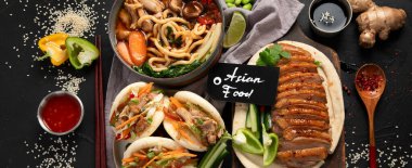 Koyu arkaplanda Çin yemekleri: tatlı ve ekşi ördek, erişte çorbası, buğulanmış çörekler. Asya tarzı ziyafet ya da açık büfe, üst manzara. Panorama