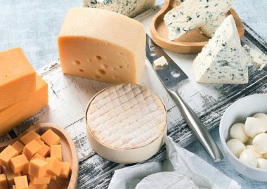 Mavi arka planda farklı peynir çeşitleri. Üst görünüm.