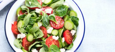 Mavi arka planda beyaz peynir tabağında taze sebze salatası. Geleneksel Yunan salatası. Üst Manzara. Kopyalama alanı olan Panorama.