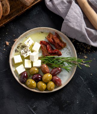 Koyu arkaplanda zeytin, zeytinyağı ve ciabatta ekmeği. Üst Manzara. Boşluğu kopyala.