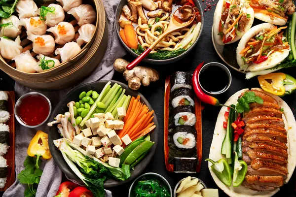 Siyah arka planda servis edilen Asya yemekleri. Asya yemekleri konsepti. Üst görünüm.