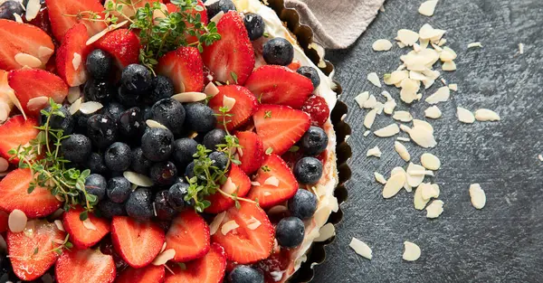 Gri arka planda taze çilek ve böğürtlenli lezzetli tart. Üst Manzara. Boşluğu kopyala.