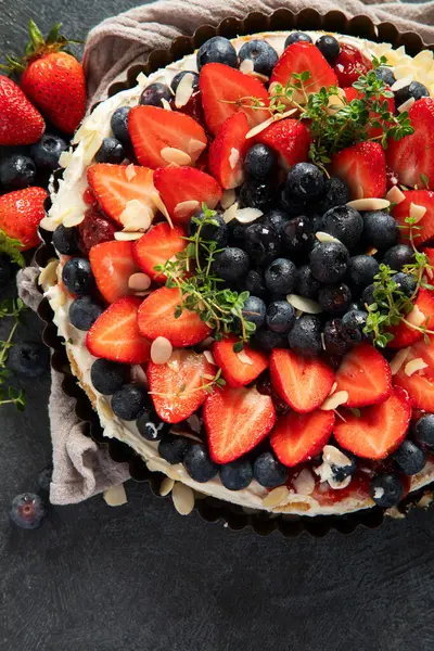 Gri arka planda taze çilek ve böğürtlenli lezzetli tart. Üst Manzara. Boşluğu kopyala.