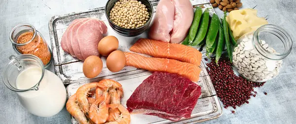 Yüksek proteinli besinler, balık, et, gri arka planda yumurtalar. Sağlıklı beslenme ve beslenme konsepti. Üst Manzara. Panorama.