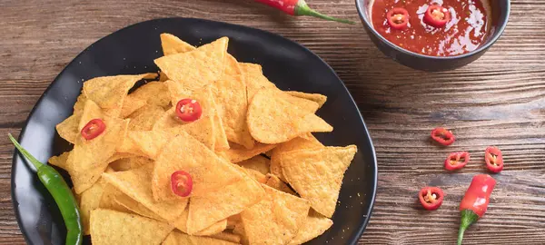 Tahta arka planda Meksika cipsi. Biberli mısır cipsi. Üst Manzara. Panorama.